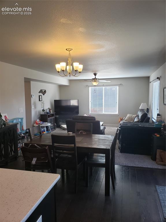 Image 4 of 34: Open-concept living area featuring a dining space with dark wood-finish flo