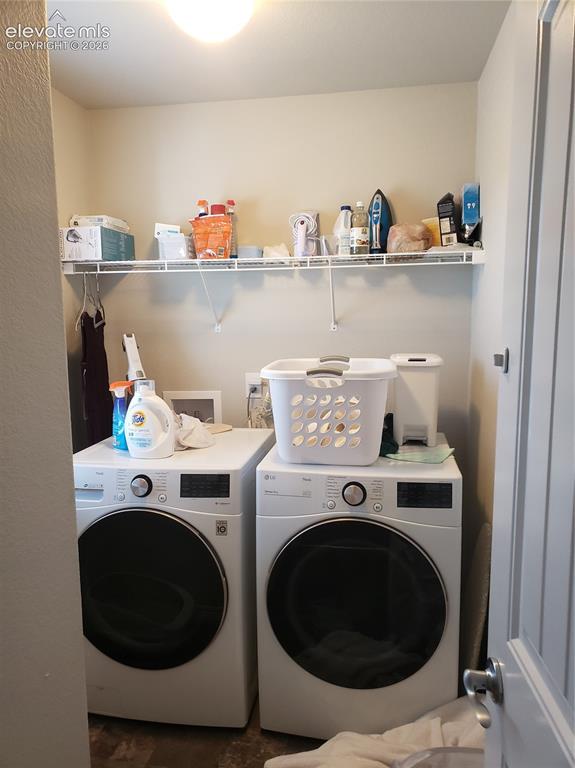 Image 8 of 34: Dedicated laundry area featuring a front-load washer and dryer, overhead wi