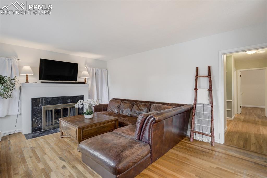 Image 19 of 48: Living room featuring light wood-style flooring and a premium fireplace