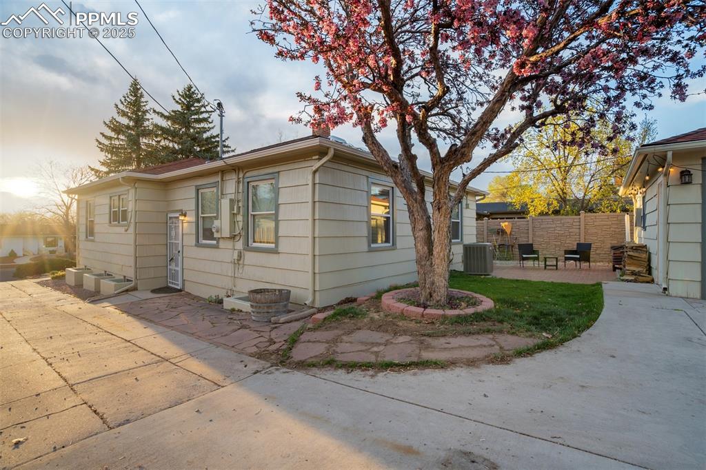 Image 2 of 48: View of side of home featuring a patio area and a central AC unit