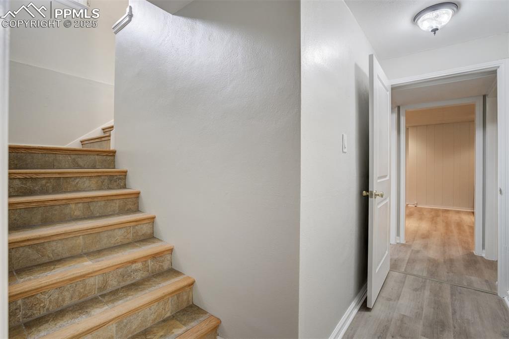 Image 28 of 48: Stairway featuring wood finished floors and baseboards