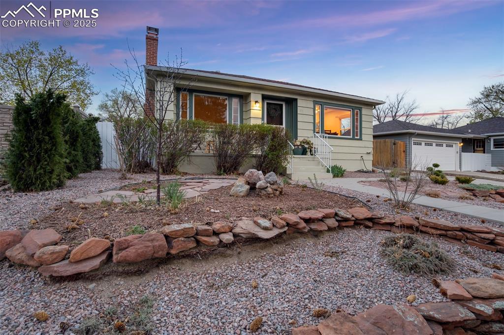 Image 4 of 48: View of front of property with a chimney and an attached garage