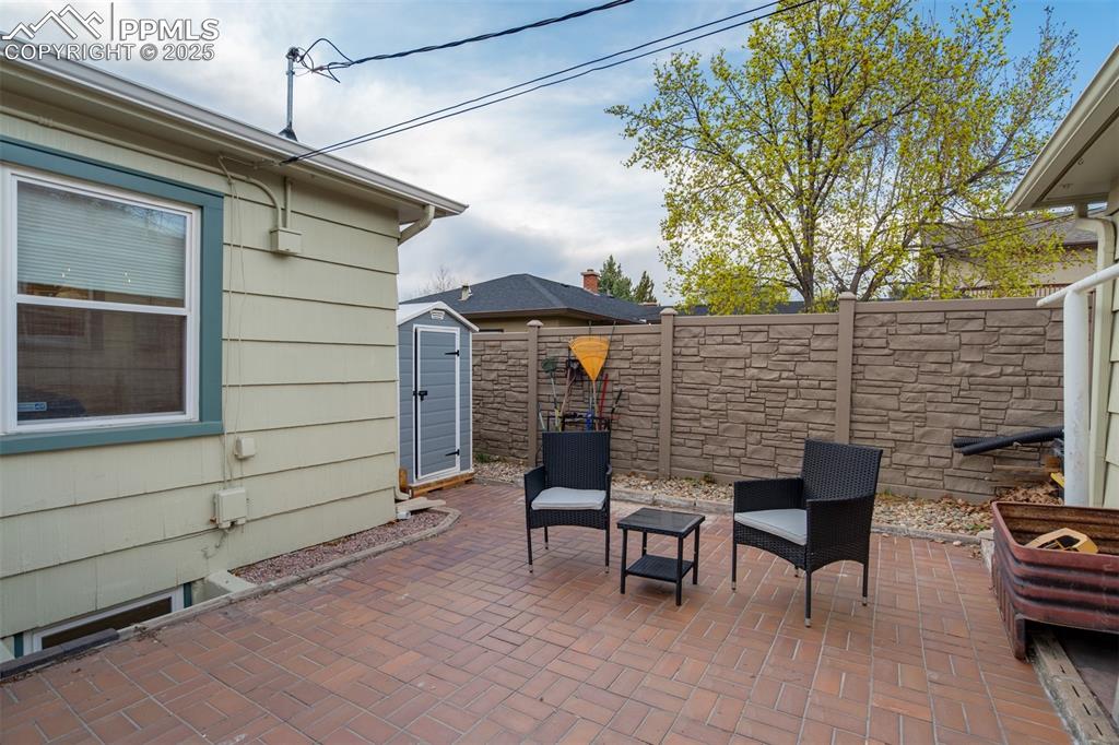 Image 42 of 48: Fenced backyard featuring a patio area and a shed