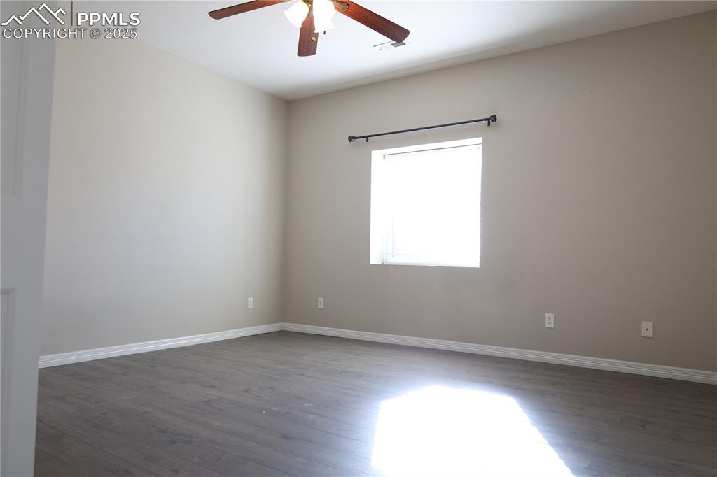 Image 34 of 49: Unfurnished room with dark wood-style flooring and ceiling fan