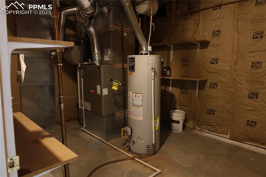 Image 36 of 49: Large utility room with water heater and heating unit