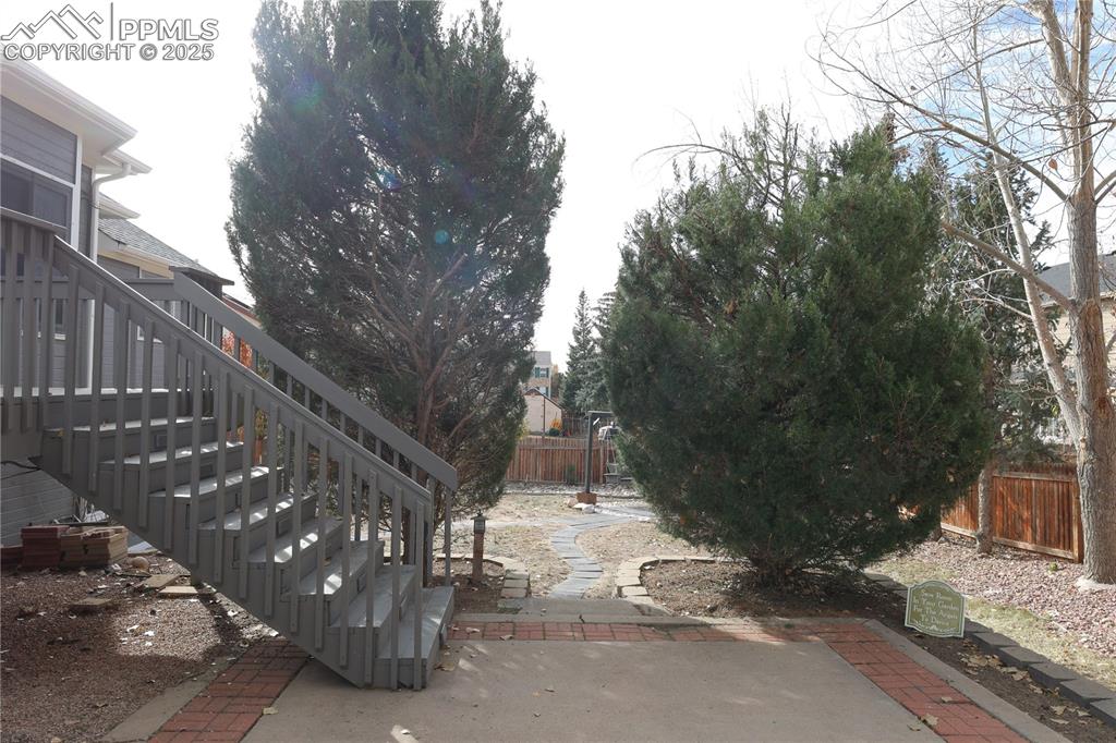 Image 43 of 49: Fenced backyard with stairway