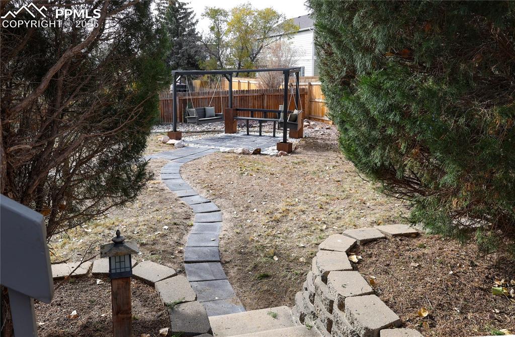 Image 45 of 49: Fenced backyard with a patio area