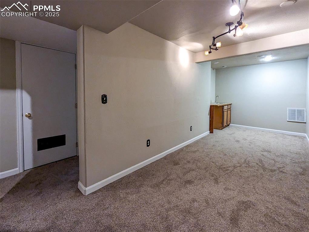Image 25 of 27: Basement Living Room with Wet Bar