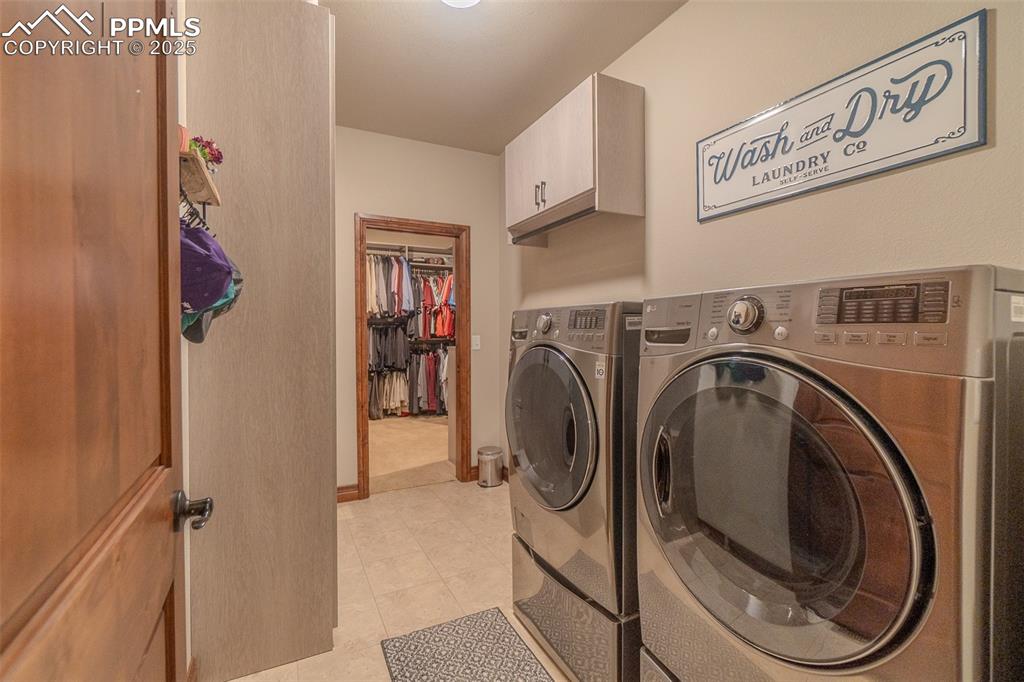 Image 25 of 50: main level laundry room with built in cabinetry