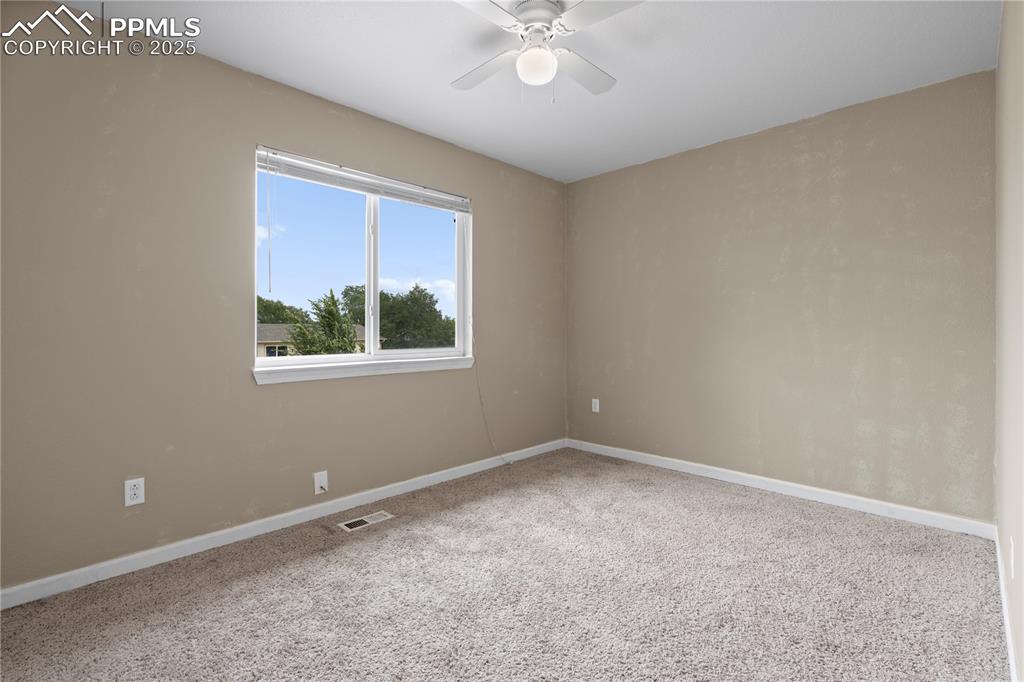 Image 11 of 34: Carpeted spare room with baseboards and ceiling fan
