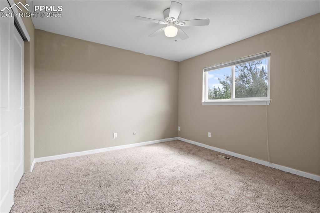 Image 12 of 34: Unfurnished room with light carpet and a ceiling fan