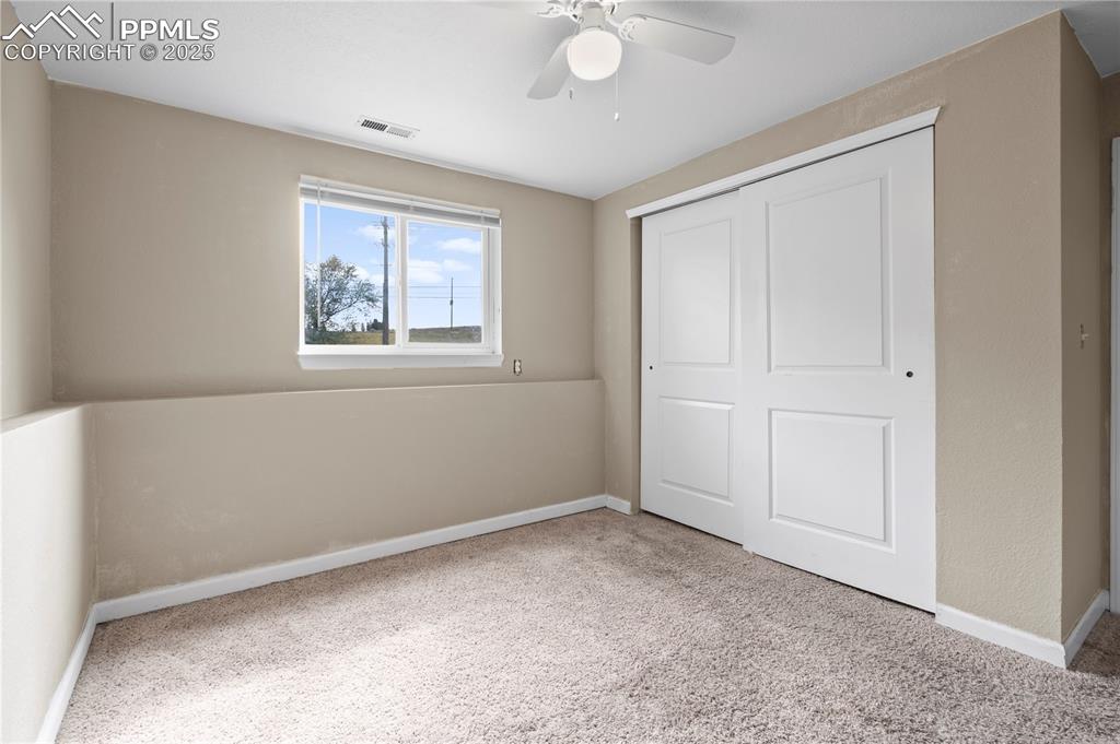 Image 18 of 34: Unfurnished bedroom featuring carpet floors, a closet, and ceiling fan