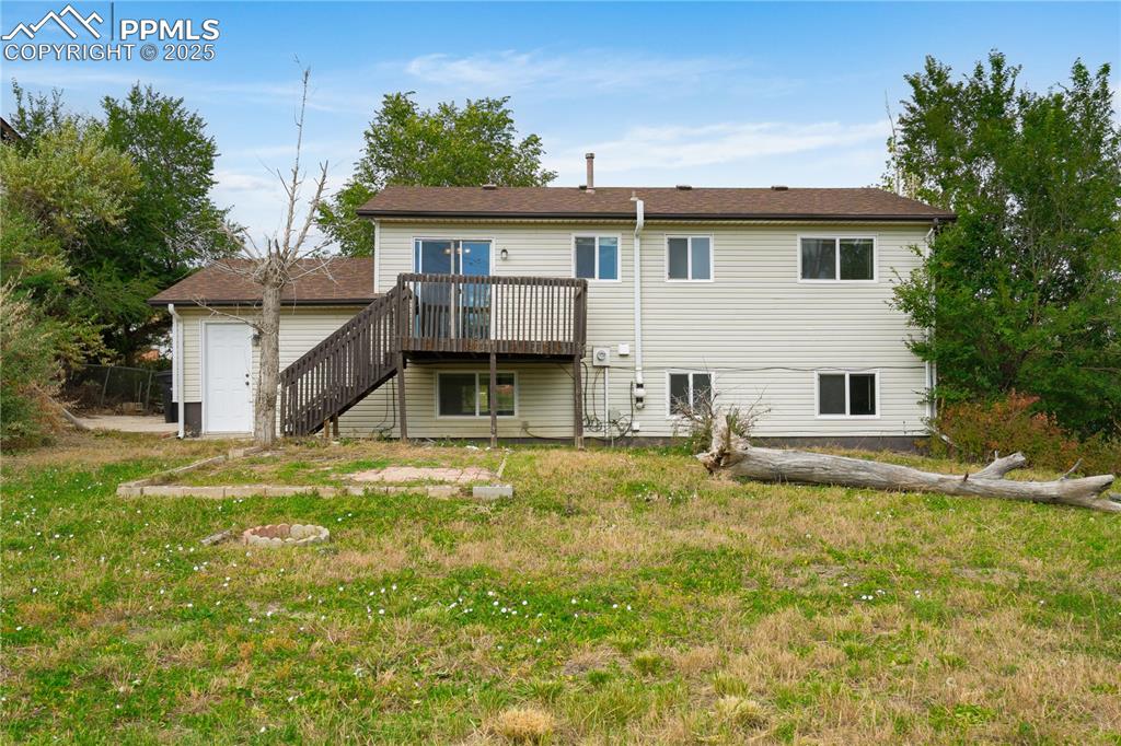 Image 22 of 34: Back of property with stairs, a deck, and a yard