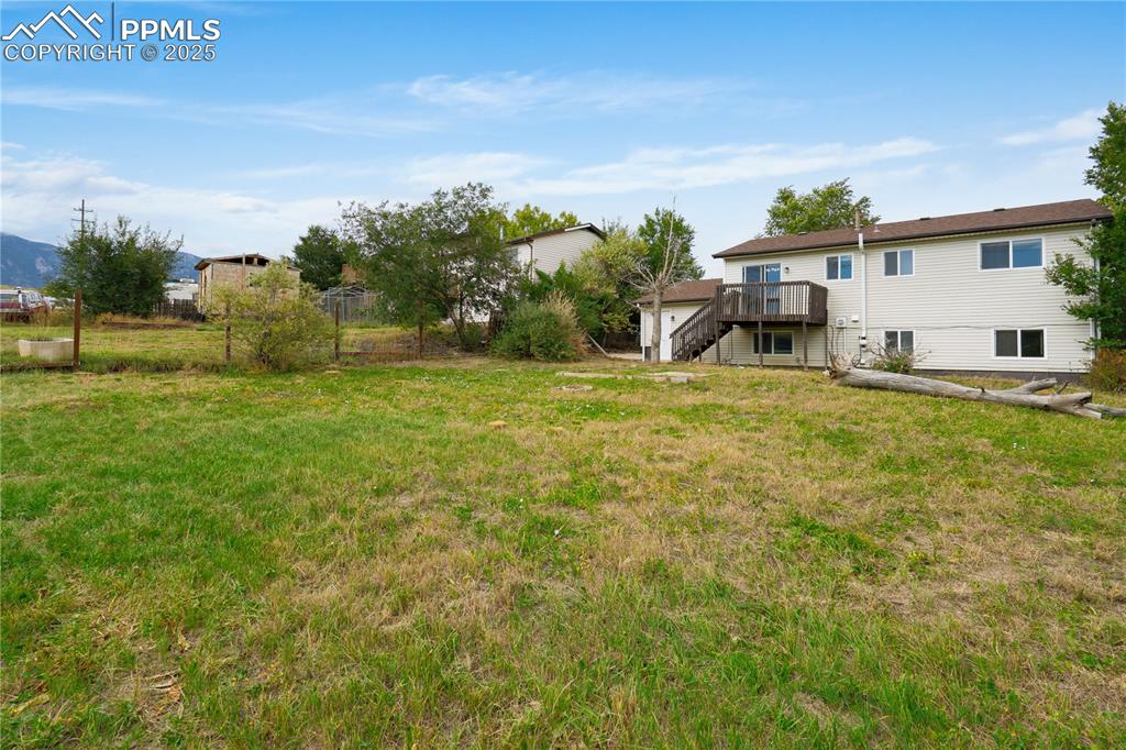 Image 23 of 34: View of yard with a deck and stairway