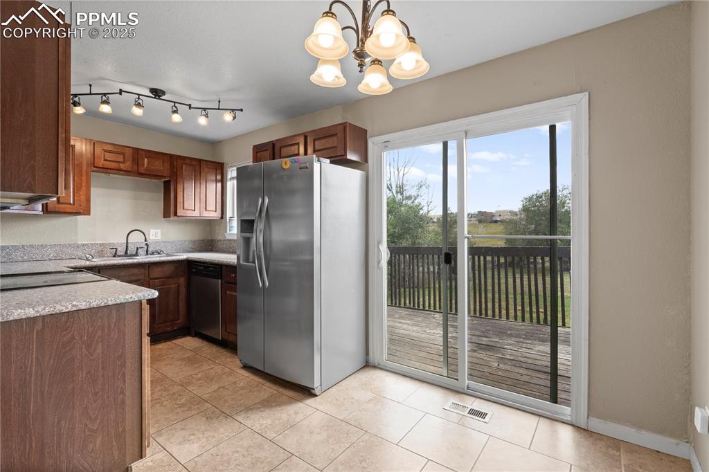 Image 6 of 34: Kitchen featuring appliances with stainless steel finishes, light counterto