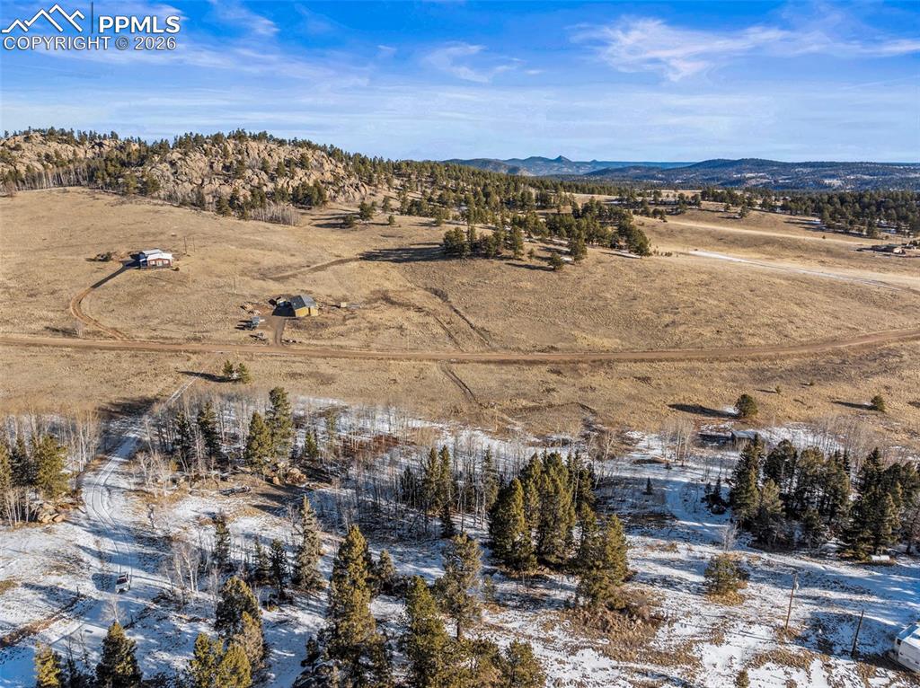 Image 12 of 25: Aerial view of sparsely populated area with a mountain backdrop