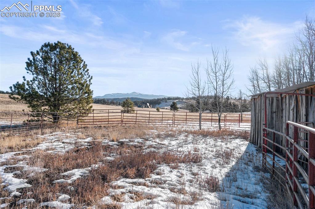 Image 20 of 25: Yard covered in snow with a rural view