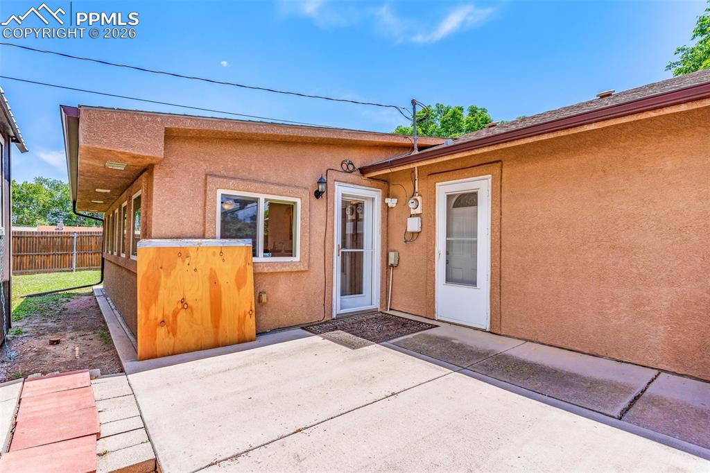 Image 30 of 42: Doorway to property with stucco siding and a patio area