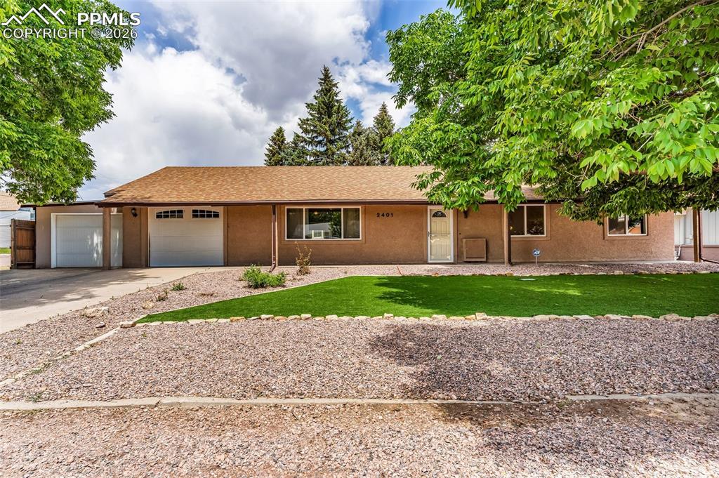 Image 39 of 42: Single story home with concrete driveway, a front lawn, a garage, and stucc