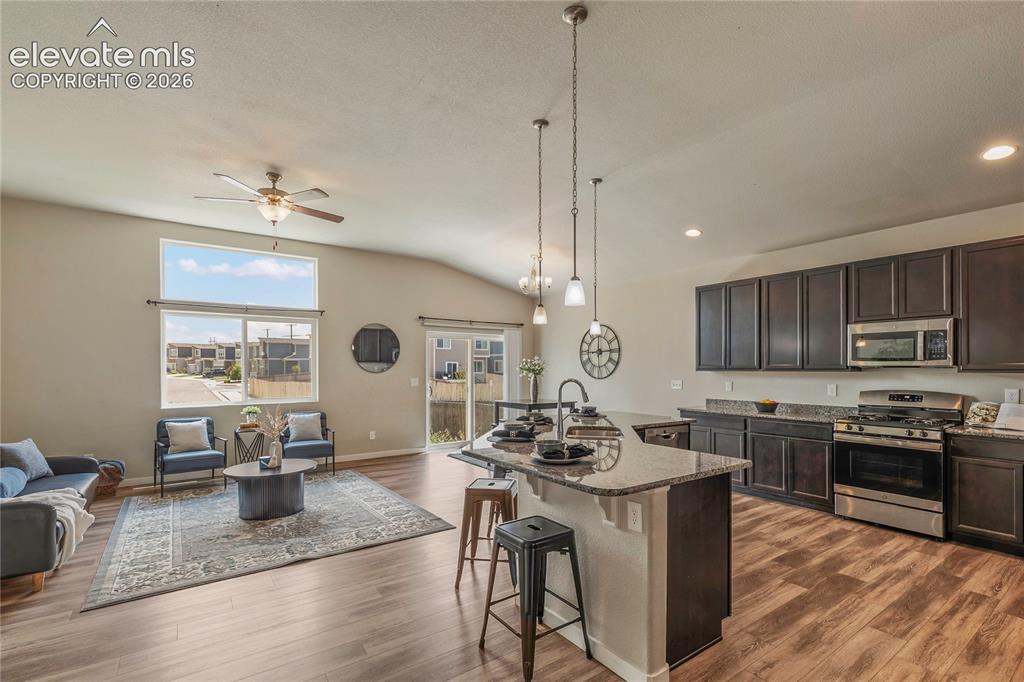 Image 7 of 29: Kitchen with island complete with breakfast bar is open to the living room.