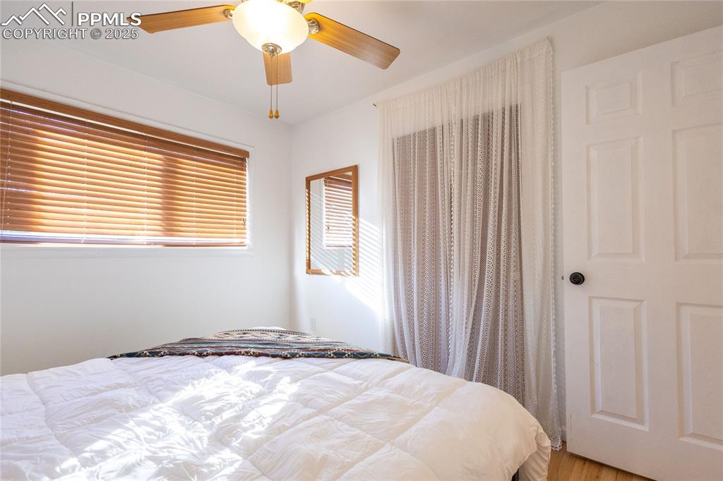 Image 13 of 27: Bedroom with ceiling fan and wood finished floors