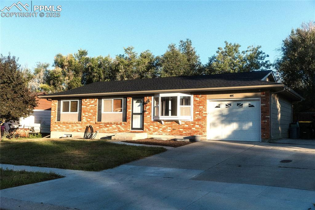 Image 3 of 27: Ranch-style home featuring brick siding, a garage, concrete driveway, and a