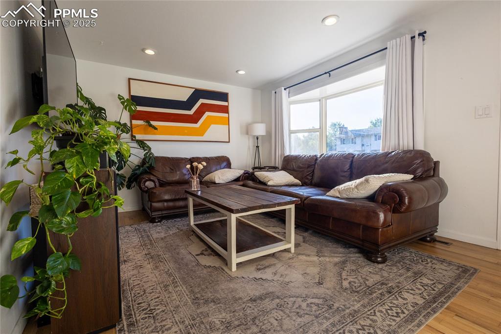 Image 7 of 27: Living room with wood finished floors and recessed lighting