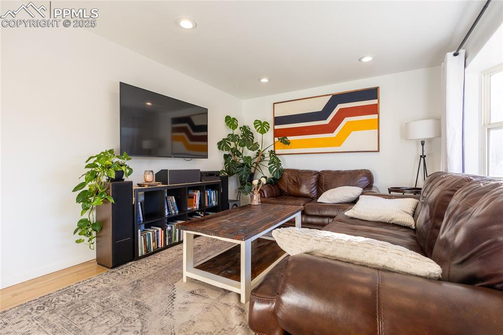 Image 8 of 27: Living room with light wood-type flooring and recessed lighting