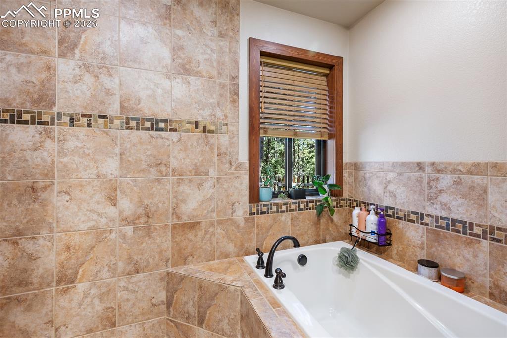 Image 14 of 31: Main level Primary bath featuring a luxurious soaking tub!