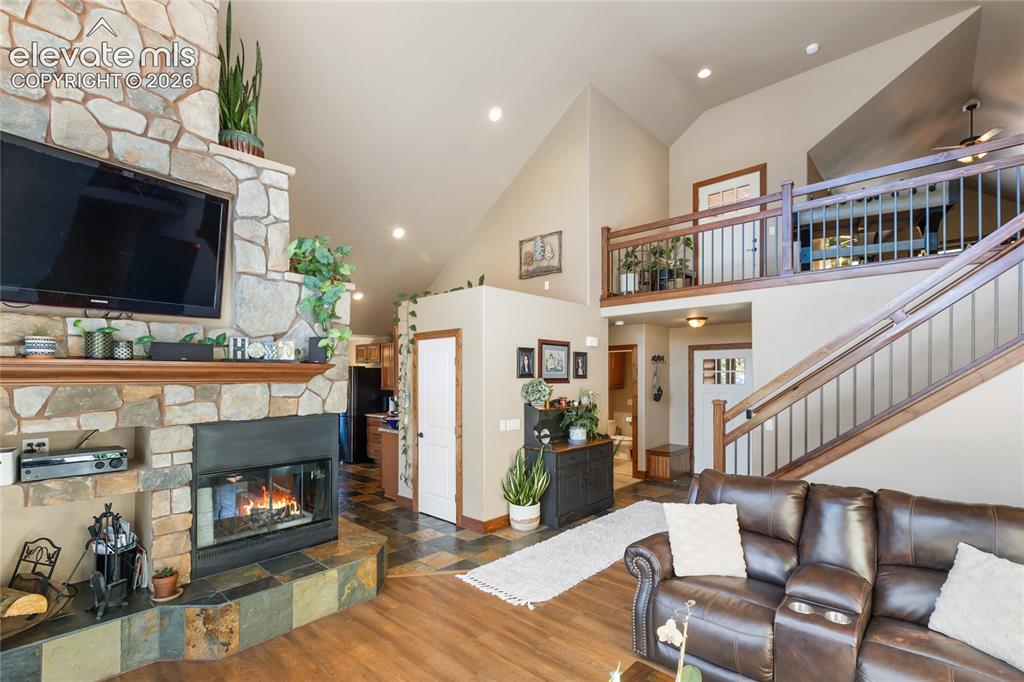 Image 7 of 31: This beautiful river rock 3 sided fireplace makes this home feel so warm an