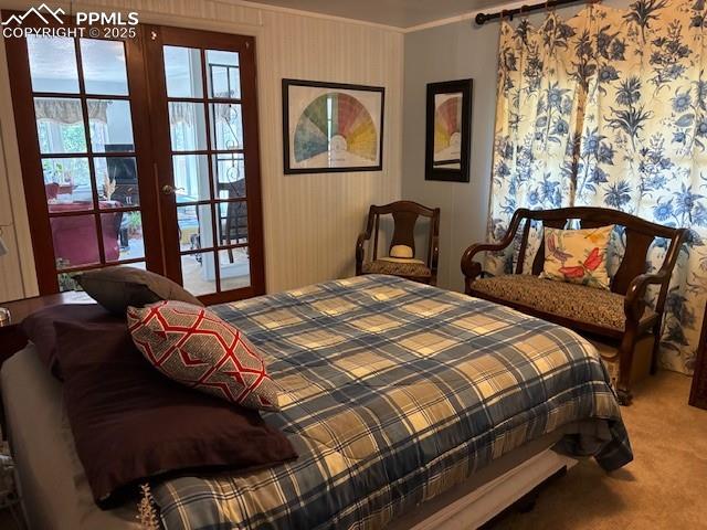 Image 12 of 30: Bedroom with light colored carpet, ornamental molding, wallpapered walls, a