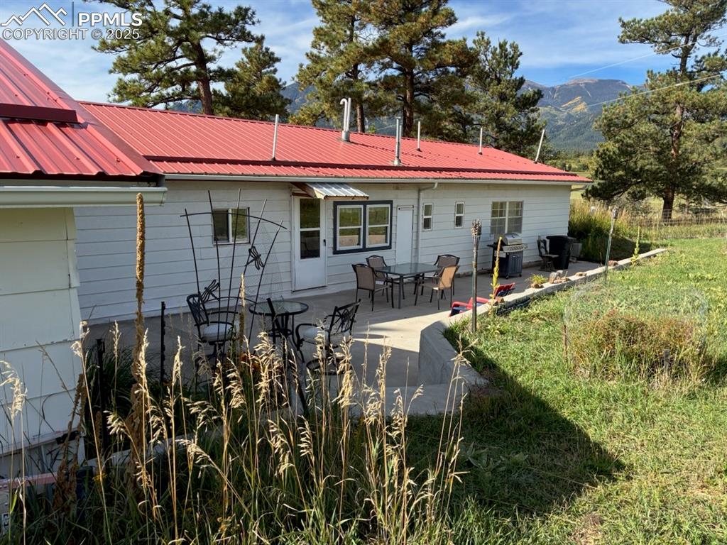 Image 28 of 30: Rear view of house with a patio area, a metal roof, a mountain view, and ou