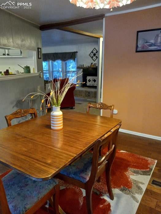 Image 3 of 30: Dining room featuring dark wood-style floors and a chandelier