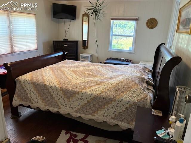 Image 7 of 30: Bedroom featuring wood finished floors and wooden walls