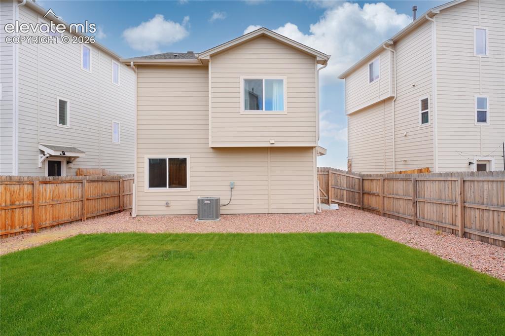 Image 21 of 21: Private backyard space featuring a manicured lawn area, surrounding gravel 