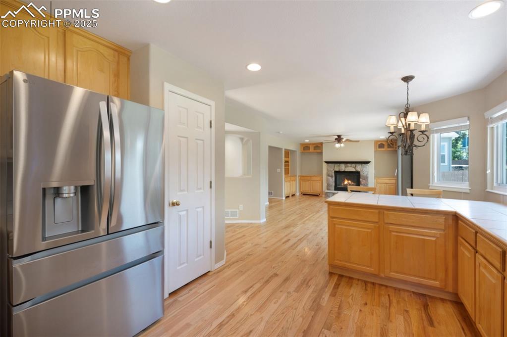 Image 10 of 37: Kitchen with stainless steel fridge with ice dispenser, a fireplace, recess