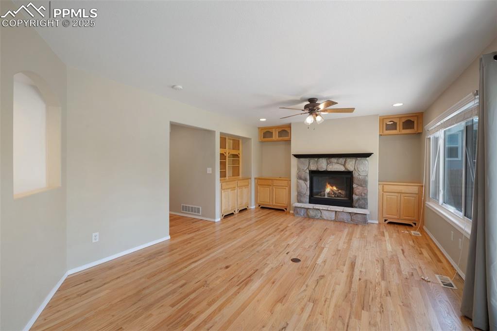 Image 12 of 37: Unfurnished living room with light wood-style flooring, a fireplace, recess