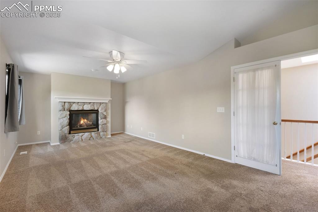 Image 19 of 37: Unfurnished living room featuring carpet flooring, a ceiling fan, and a sto