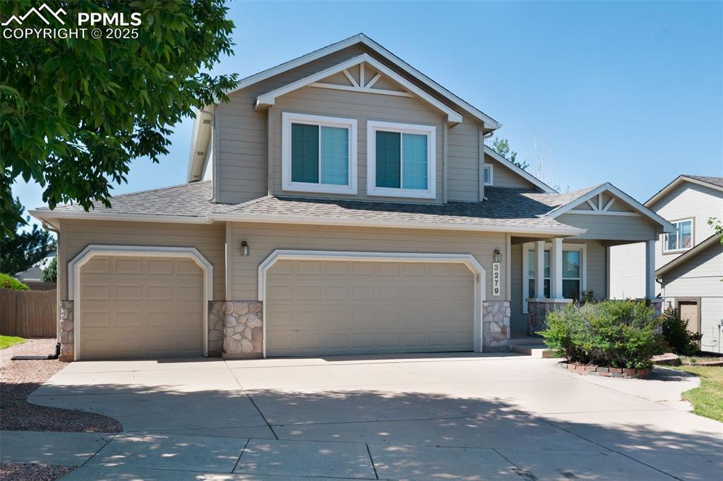 Image 2 of 37: Craftsman-style home featuring stone siding, a shingled roof, concrete driv
