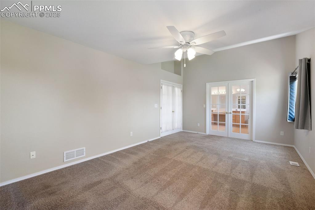 Image 20 of 37: Carpeted spare room with ceiling fan and french doors
