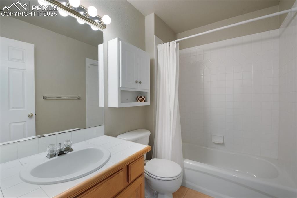 Image 28 of 37: Bathroom featuring shower / tub combo, vanity, and light tile patterned flo