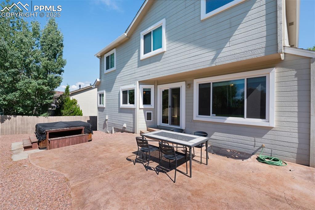 Image 31 of 37: Rear view of property featuring a hot tub, a patio area, and outdoor dining