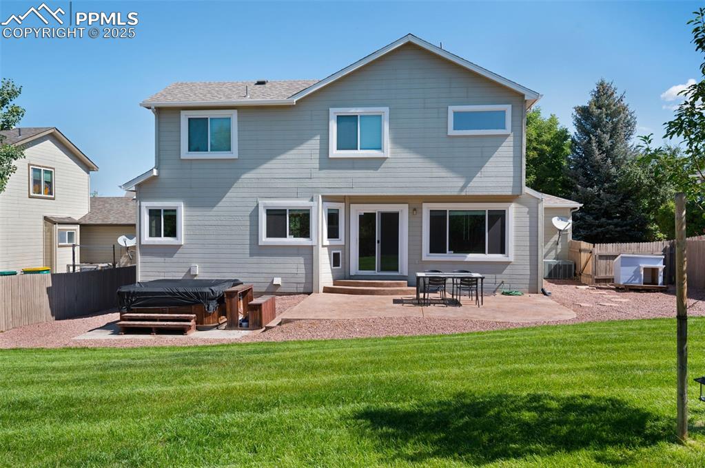 Image 32 of 37: Rear view of house featuring a hot tub, a fenced backyard, a patio area, en