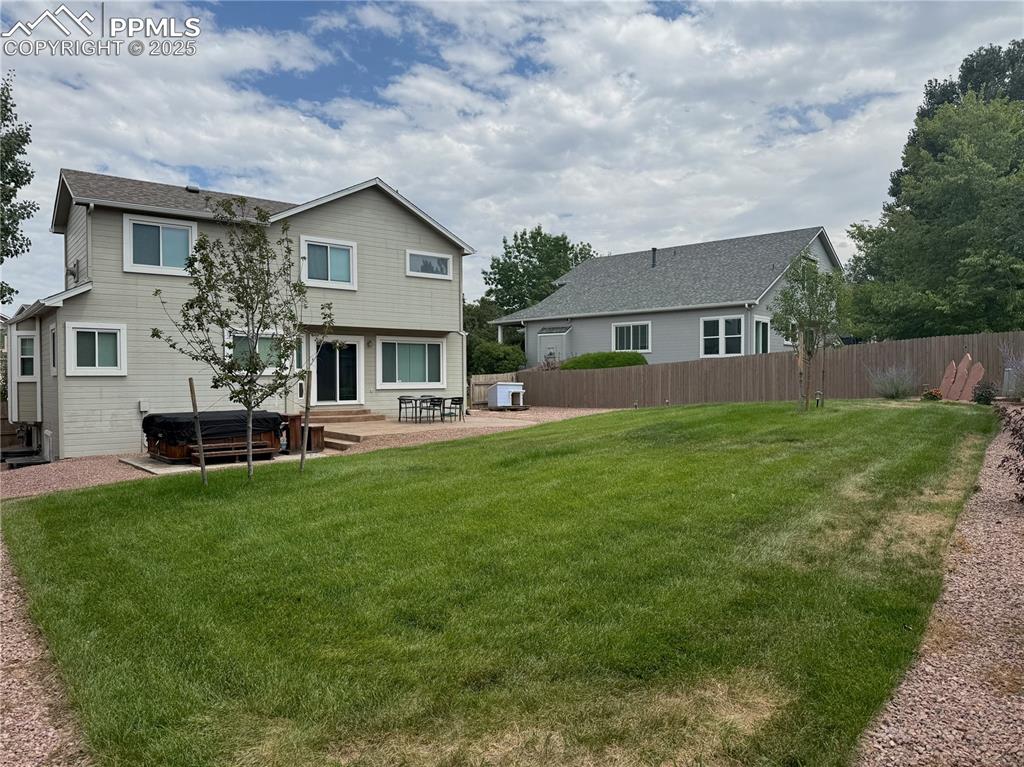 Image 33 of 37: Back of property featuring a patio area and a hot tub