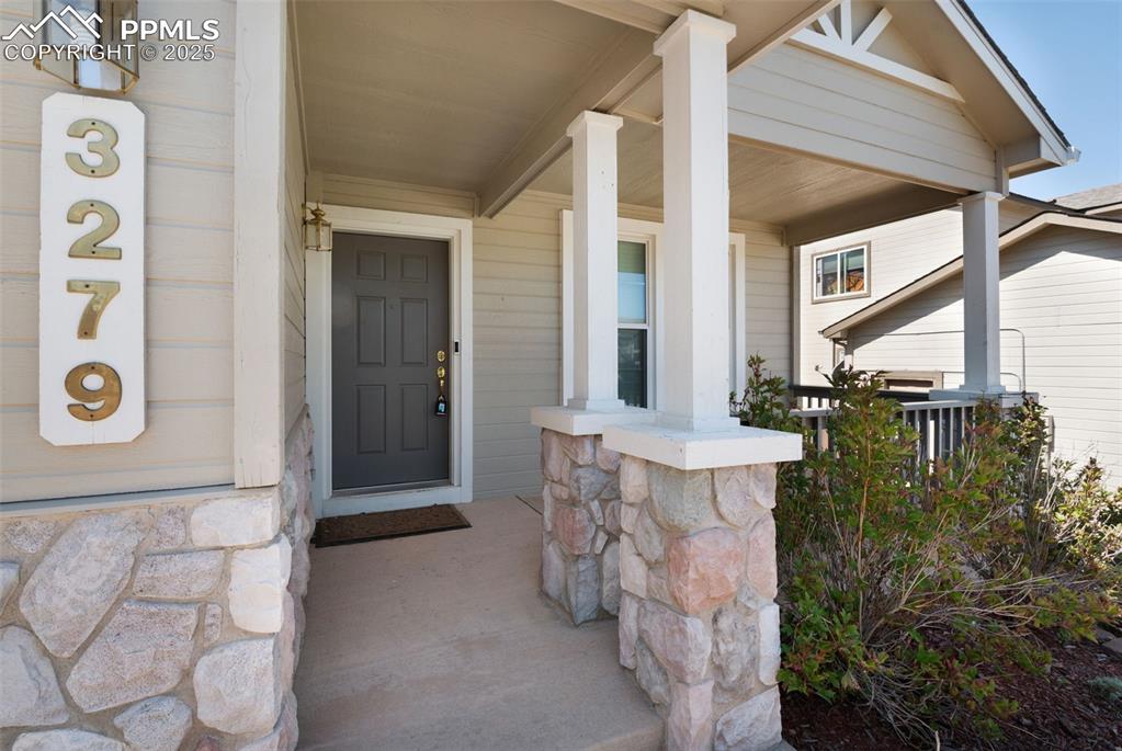 Image 4 of 37: Property entrance featuring a porch and stone siding