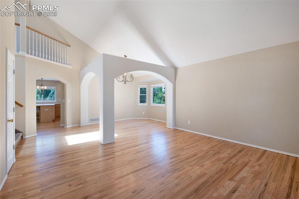 Image 5 of 37: Unfurnished living room featuring a chandelier, light wood-style floors, hi