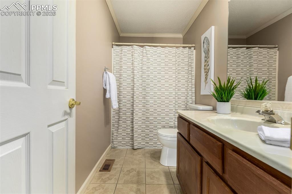 Image 19 of 30: Full bath featuring vanity, a shower with shower curtain, crown molding and