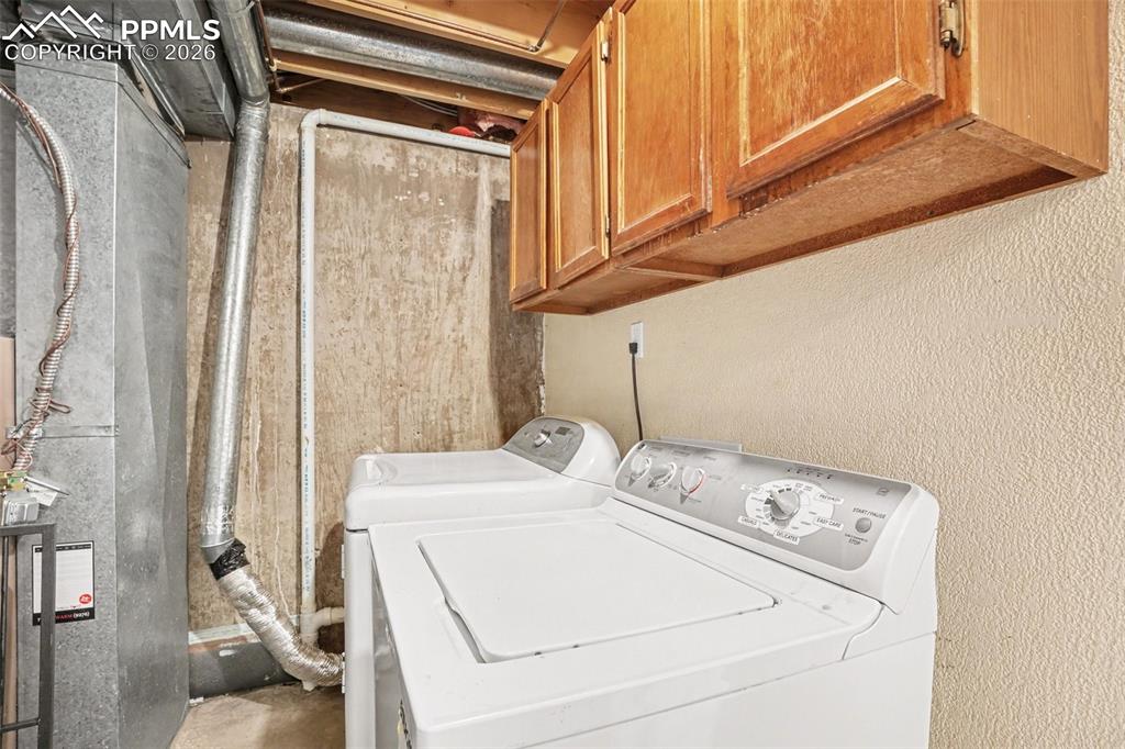 Image 16 of 25: Washer and dryer and additional storage in utility room