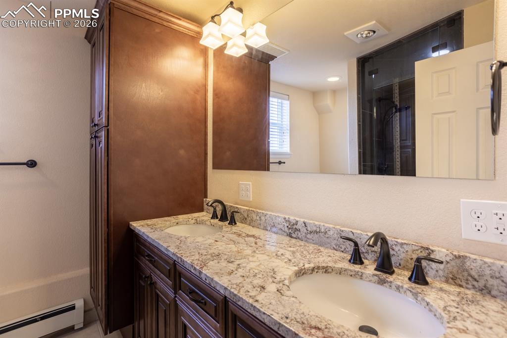 Image 33 of 50: Basement bathroom with walk in steam shower, custom cabinets, granite, and