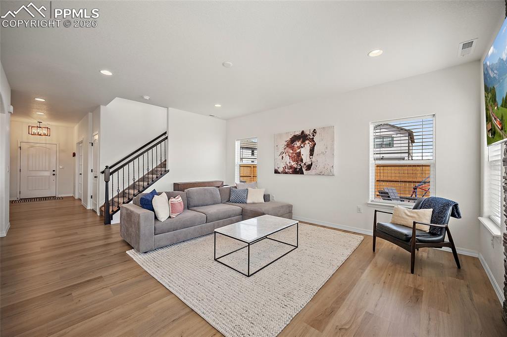 Image 10 of 45: Open-concept living space with light wood-finish flooring